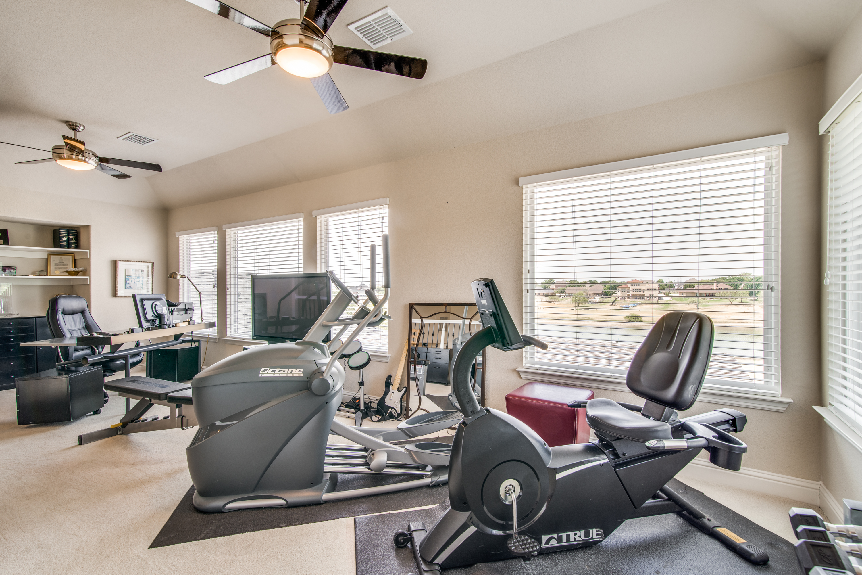 The upstairs loft with a wall of windows with a gorgeous lake view. The current owner uses this as a fitness room, however as a bonus space would do well as whatever you choose.